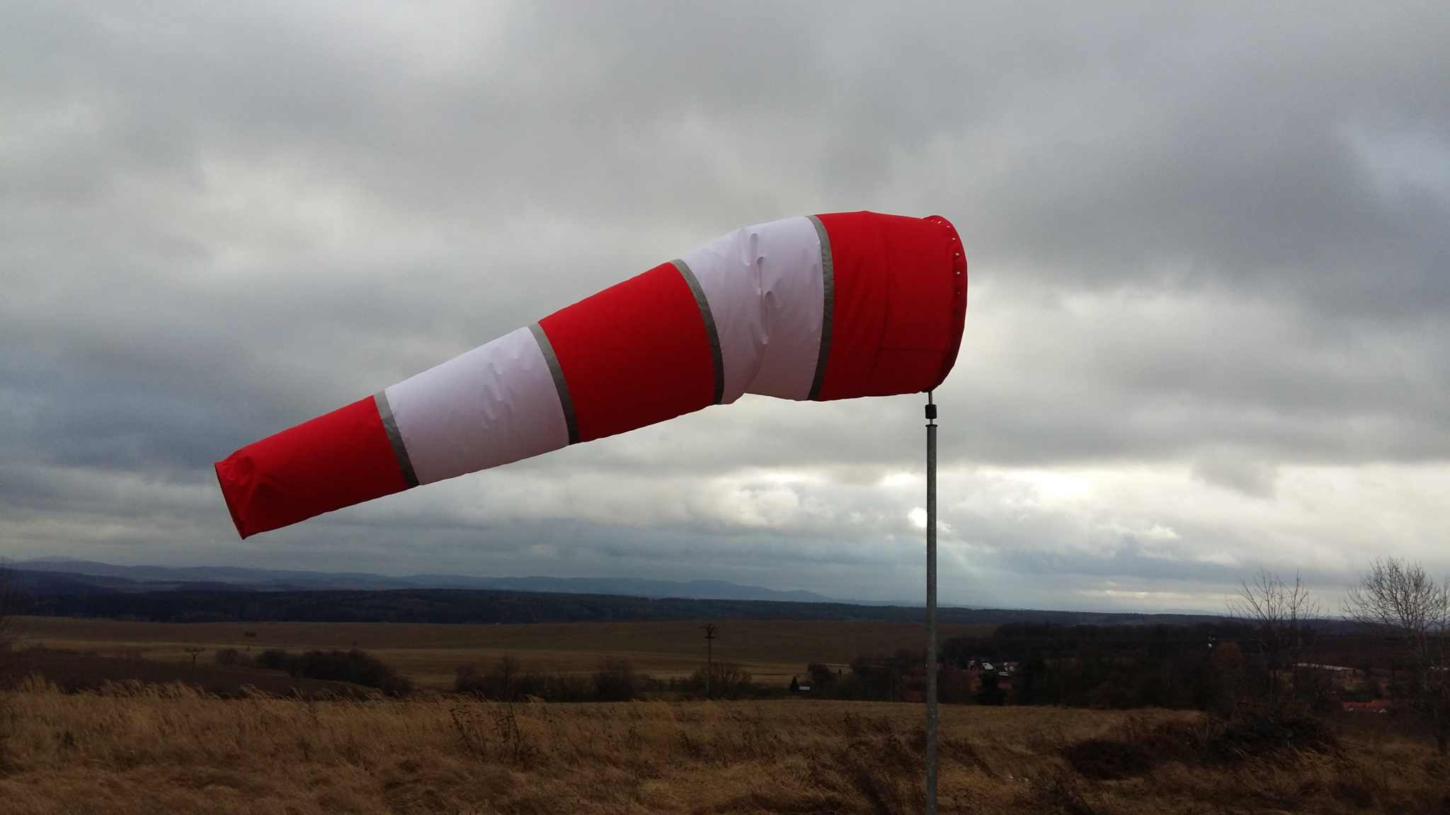 Windsackhülle für Korbdurchmesser 90 cm aufgeständert vor bewölktem Himmel.