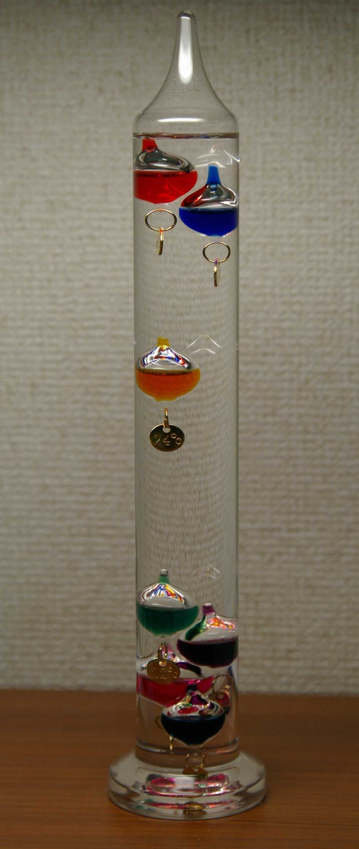 Galilei Thermometer with four bordeaux glass bulbs and gold-plated seals.