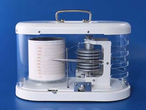 Barograph with float glass case and brass mechanism for precise air pressure measurement.