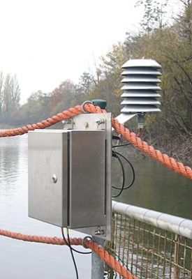 Strahlungsschutzhütte mit Aluminiumlamellen für natürliche Belüftung, montiert am Wasser.
