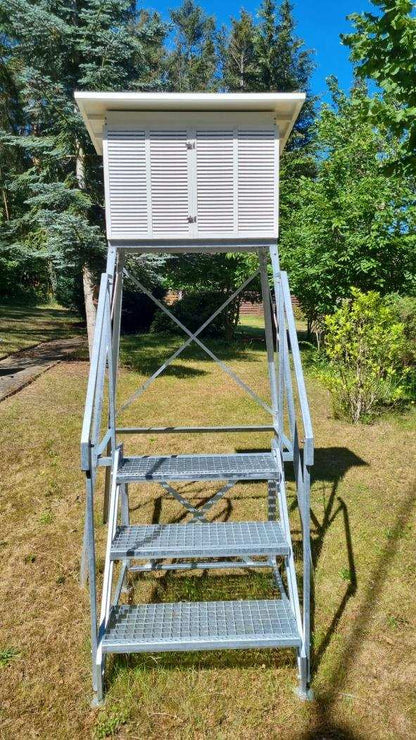 Modular weather hut with white lamella system on stand, ideal for protecting meteorological instruments.