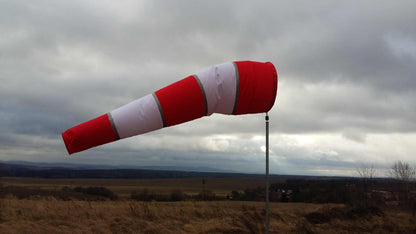 Windsackhülle für Korbdurchmesser 90 cm aufgeständert vor bewölktem Himmel.