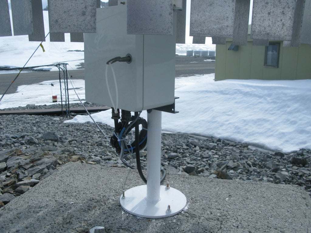 Automatischer Regenmesser UPG mit Kippwaage und robustem Aluminiumgehäuse auf Betonfläche.