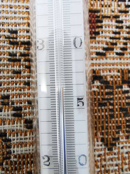 Hütten-Psychrometer-Thermometer on patterned fabric background.
