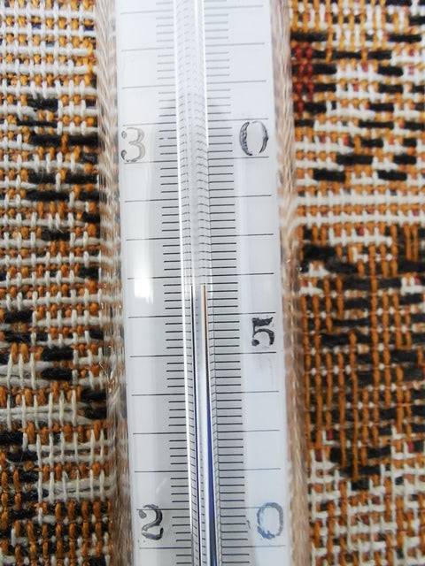 Hütten-Psychrometer-Thermometer on patterned fabric background.